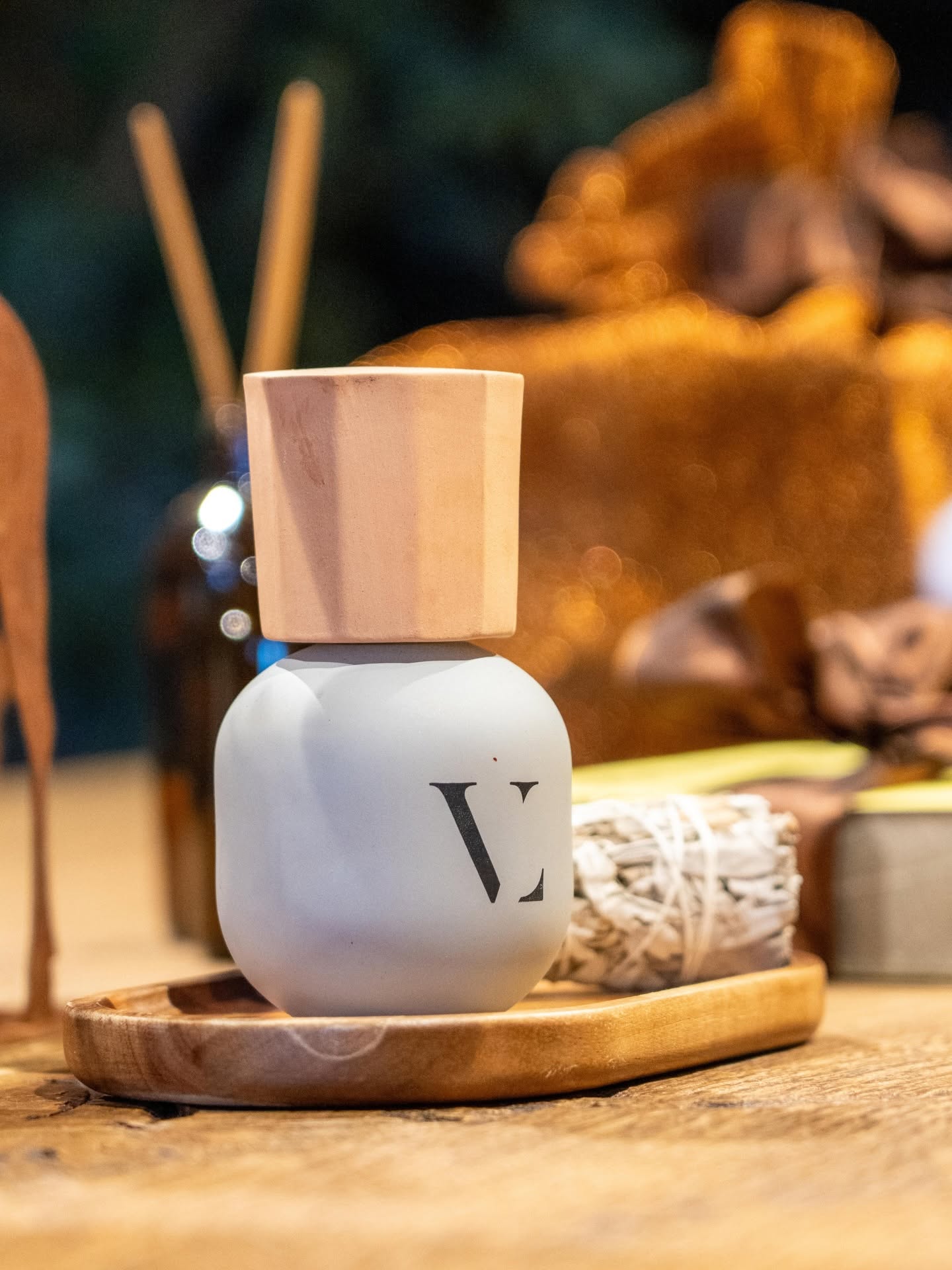 Flacone con il monogramma del salone accanto a un rametto di salvia